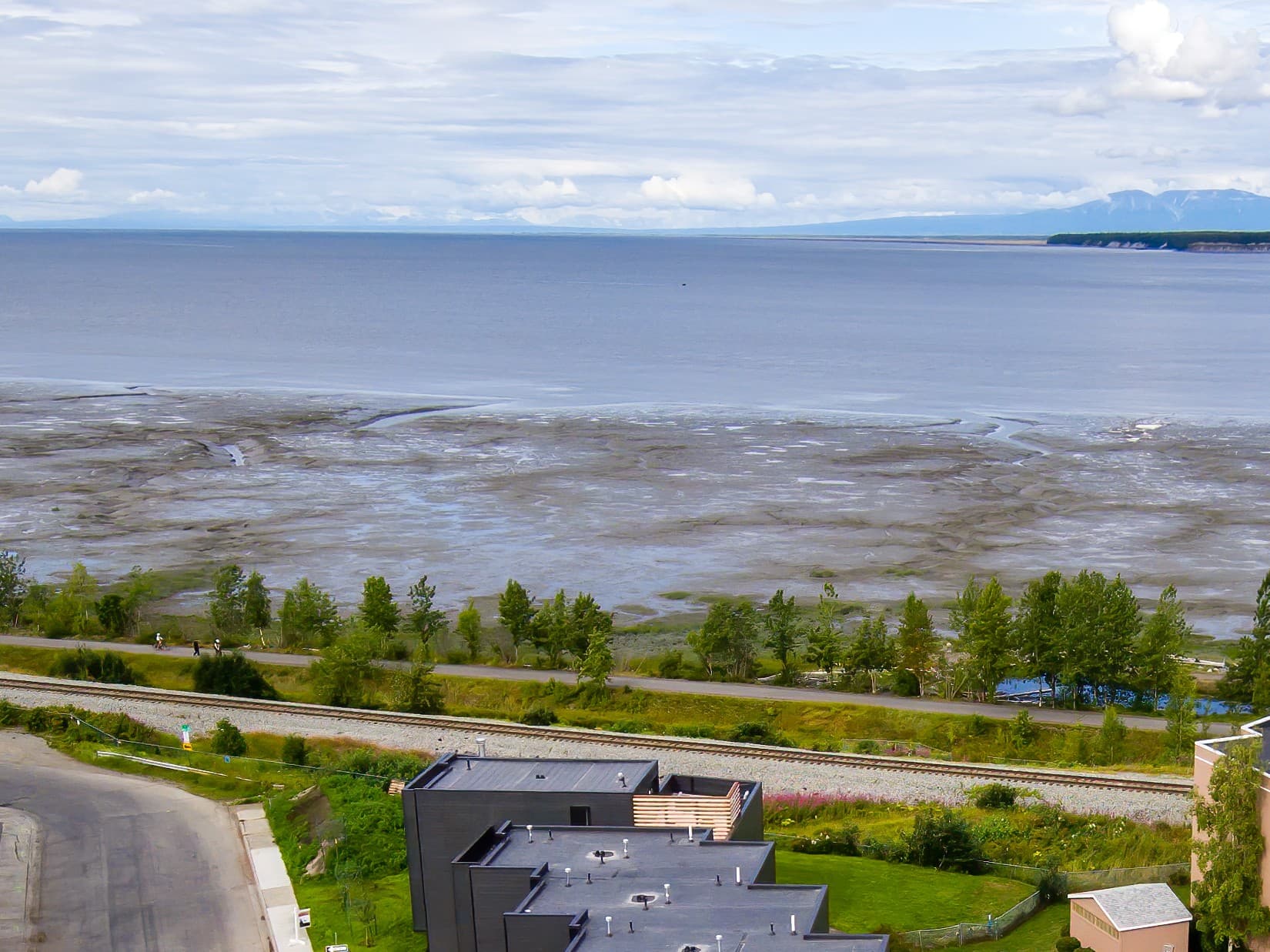 Cook Inlet and the Alaska Range seen over the Bootleggers Landing townhomes and the coastal railroad